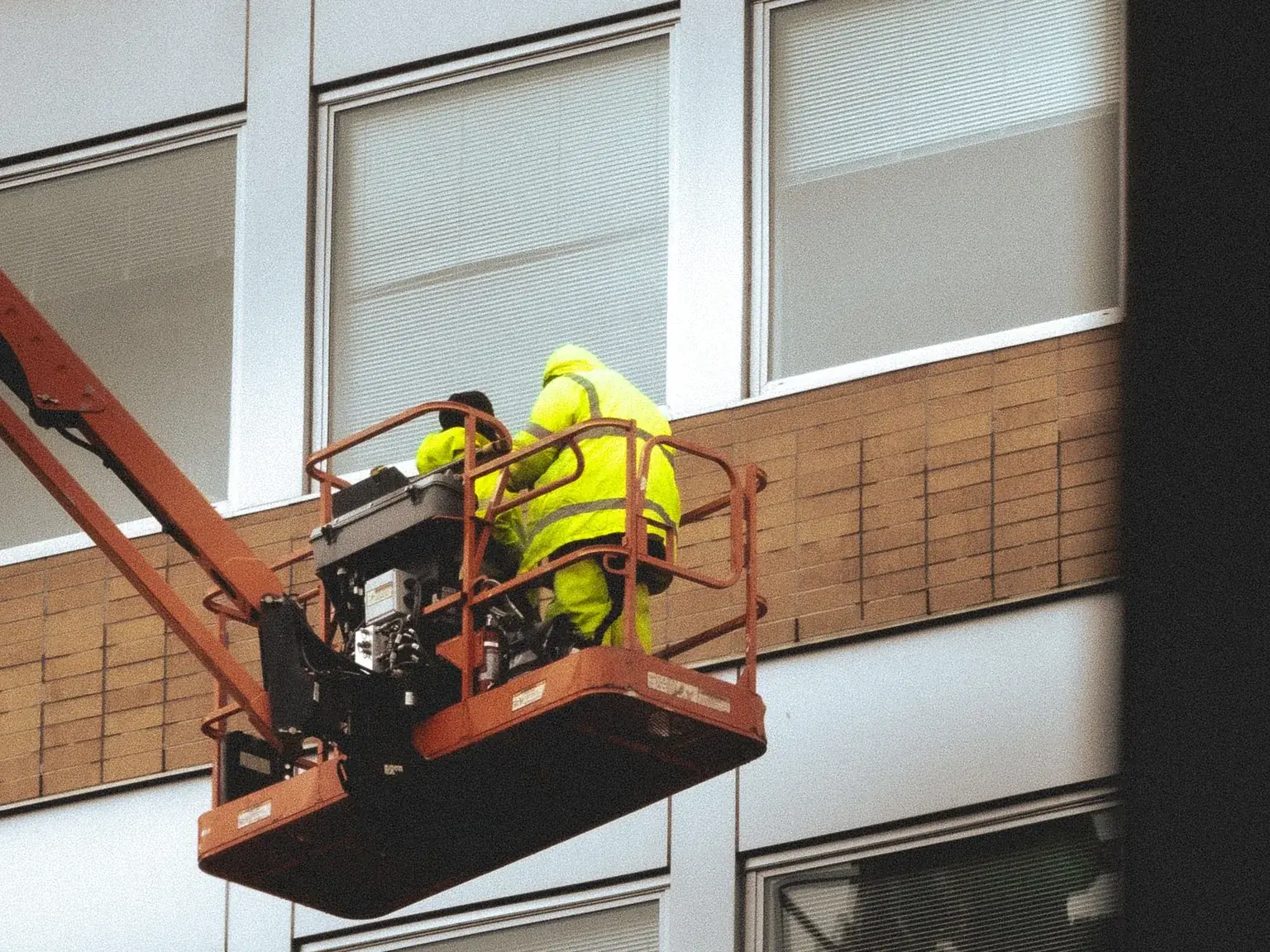 Maintenance work carried out from a lift on a commercial building exterior