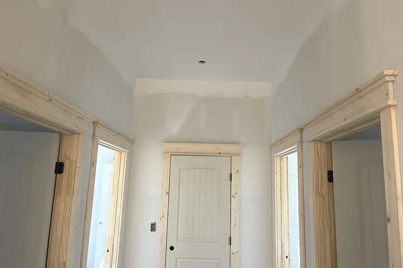 Unfinished pine casing and header trim installed around interior doorways by Guess Company